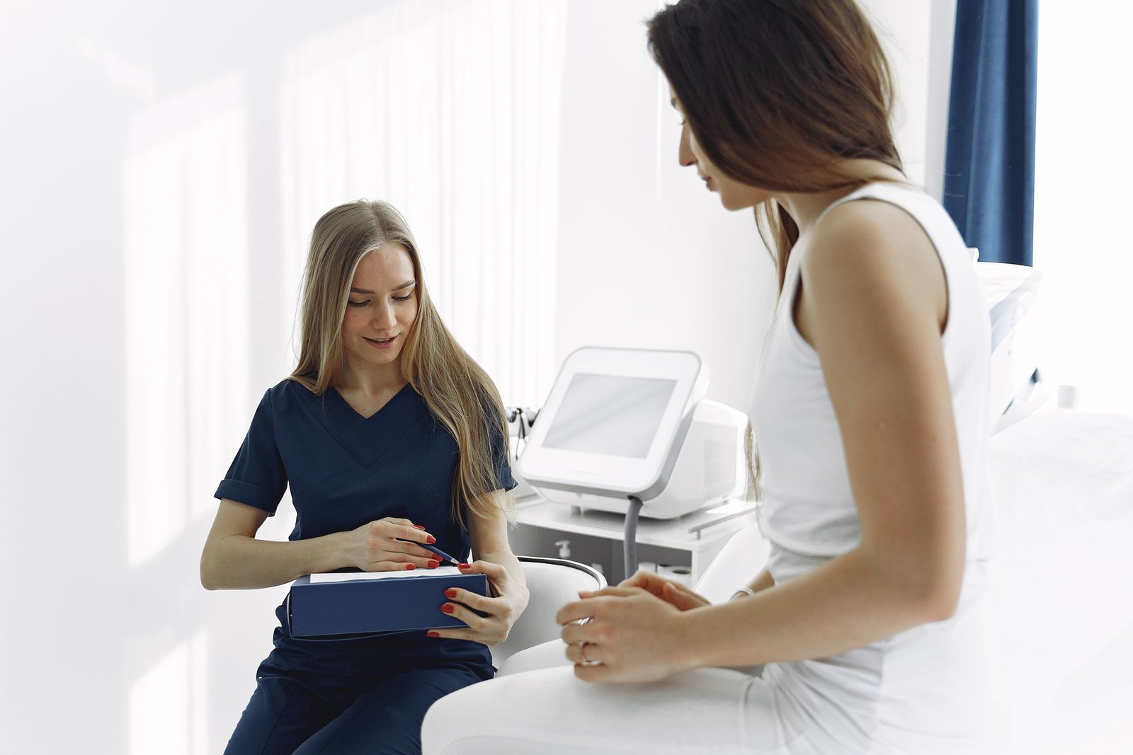 Healthcare professional recording a patient’s history during a conversation in a clinical room.